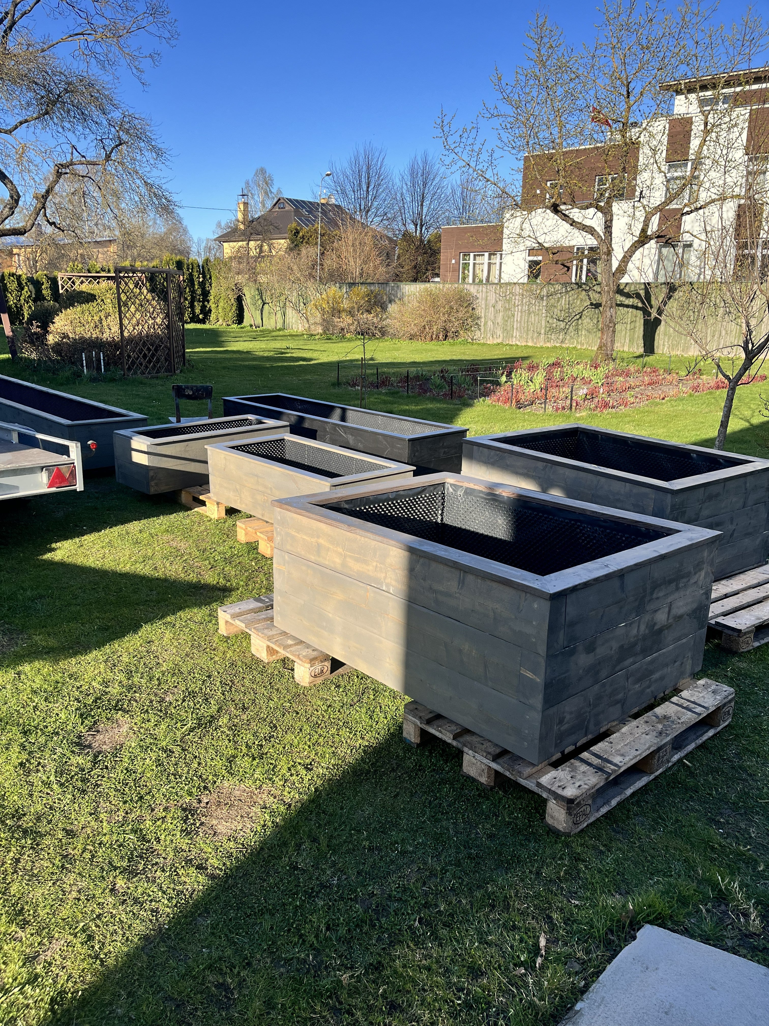 Terases wooden greenhouse and garden raised beds with lush plants and greenery for outdoor gardening.
