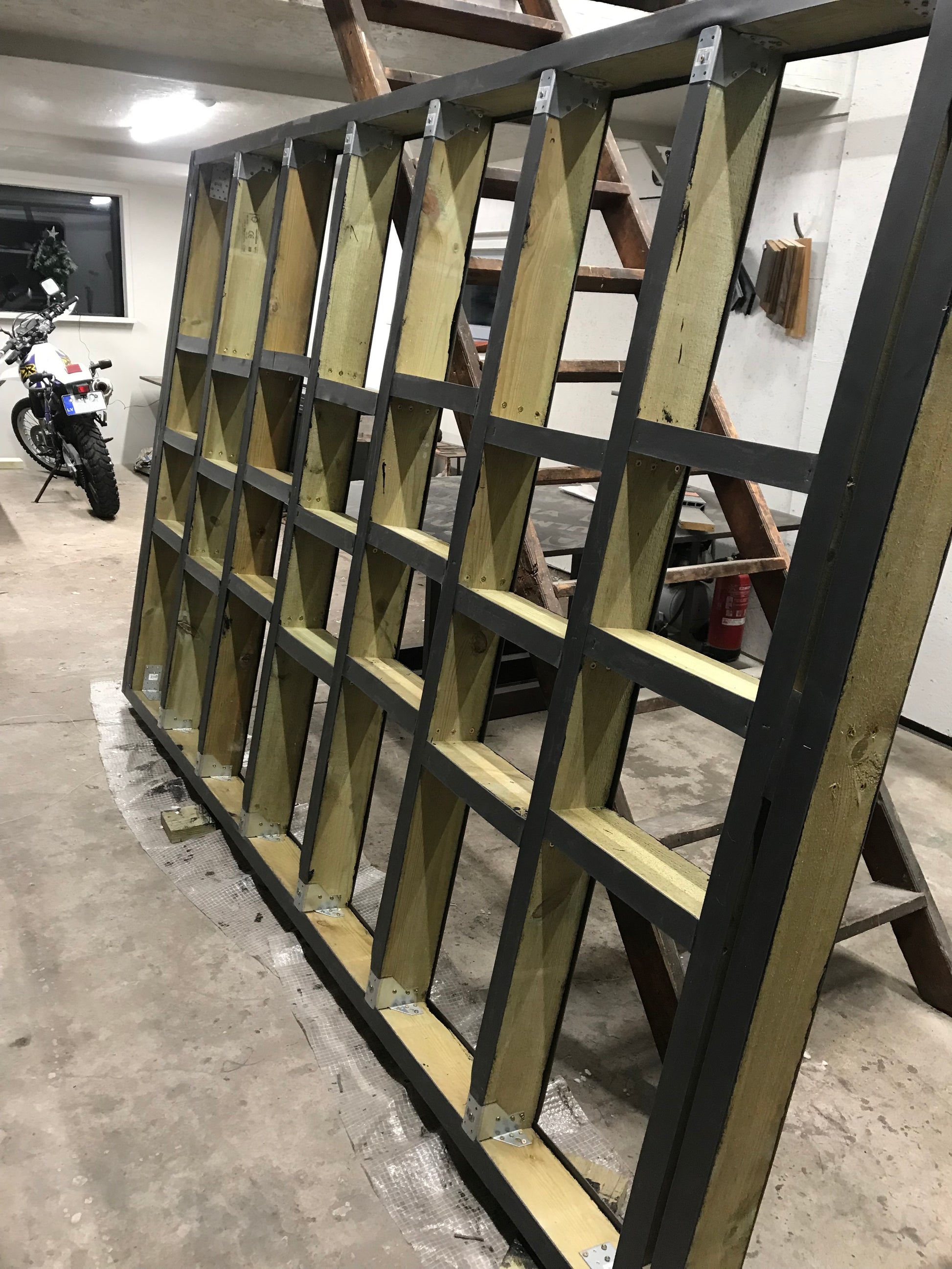 Wooden shelf structure with geometric design in a workshop setting