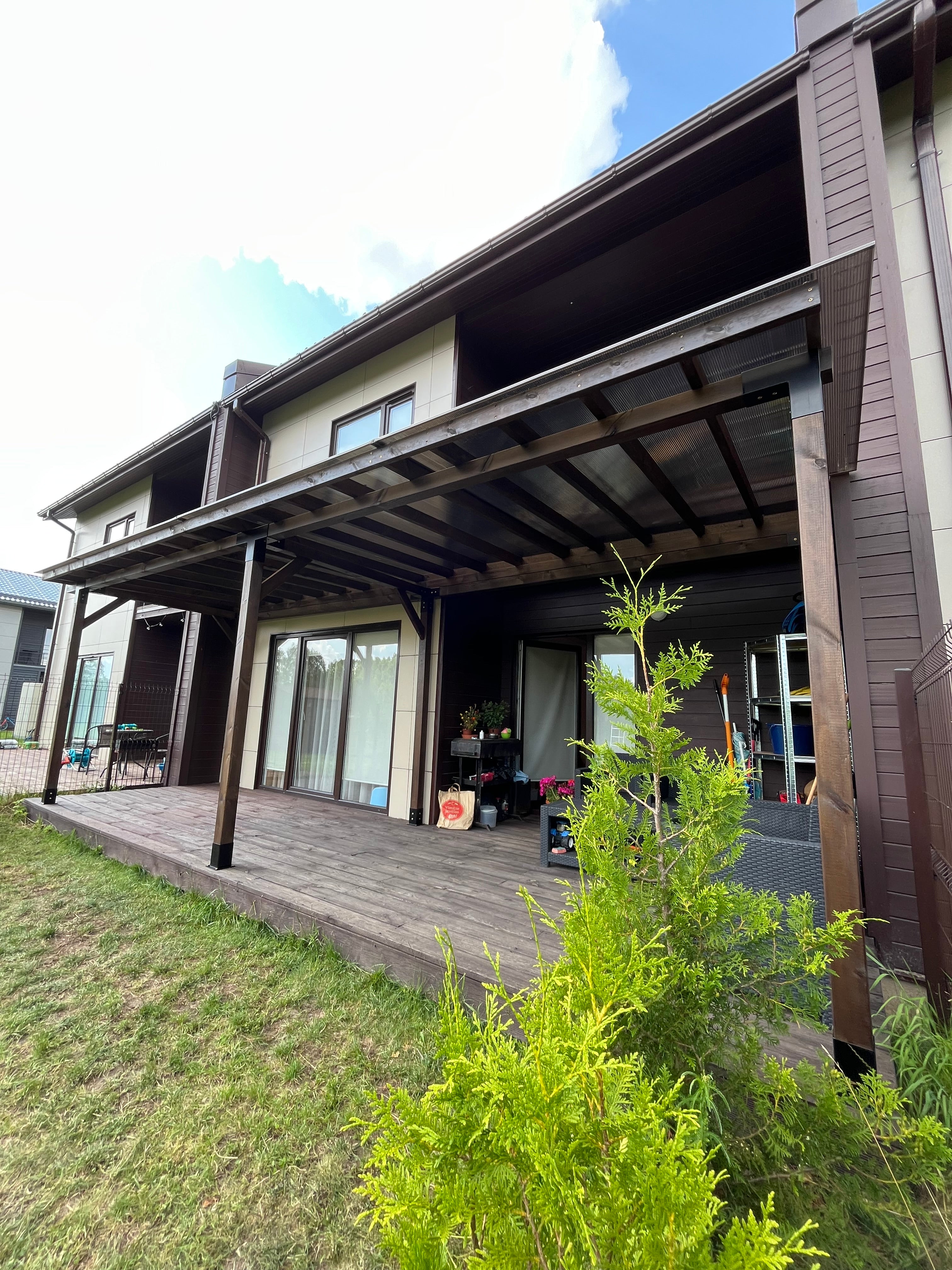 Modern house exterior with glass doors and a tree in the foreground