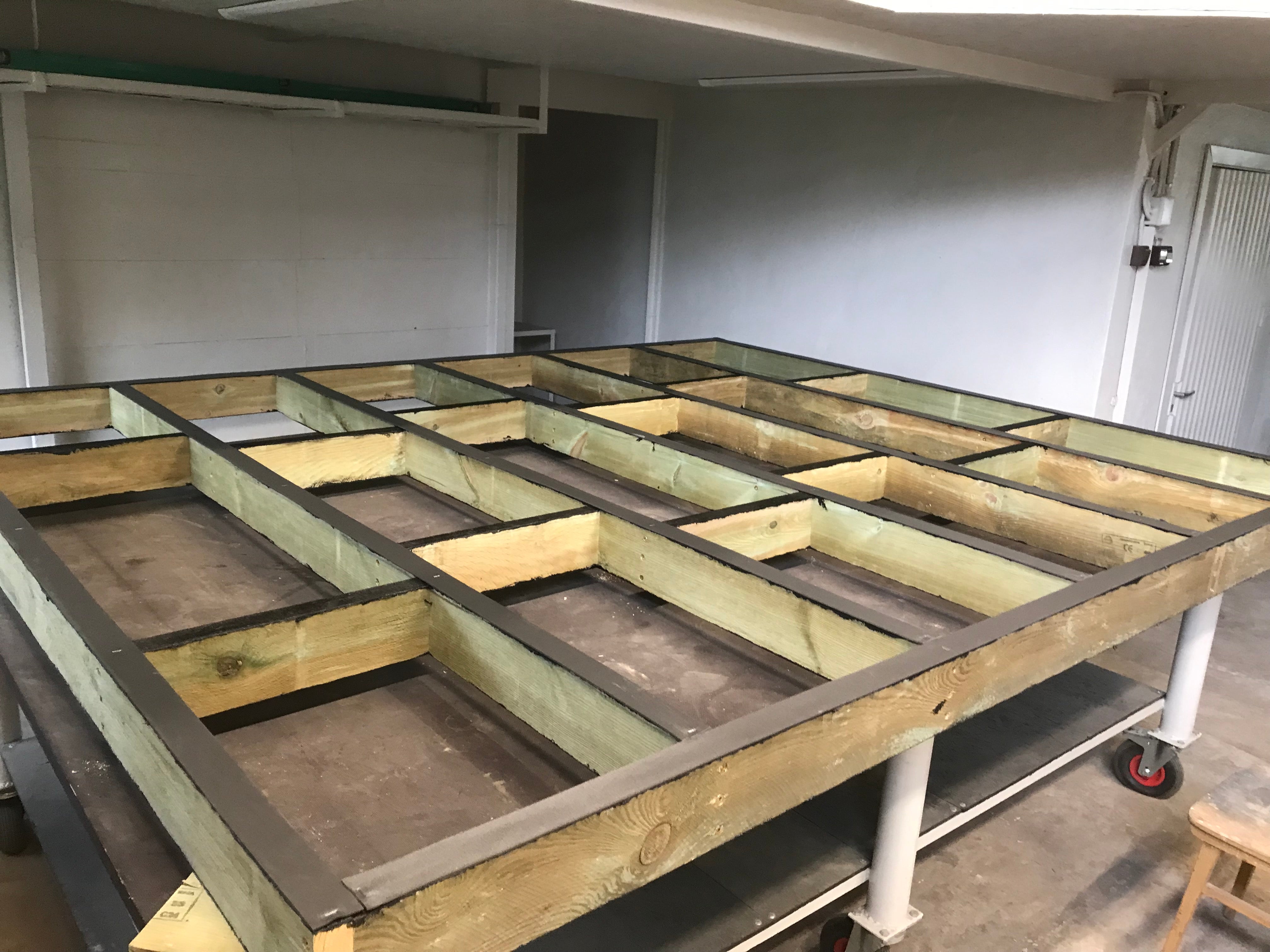 Wooden frame structure on a cart in an indoor setting