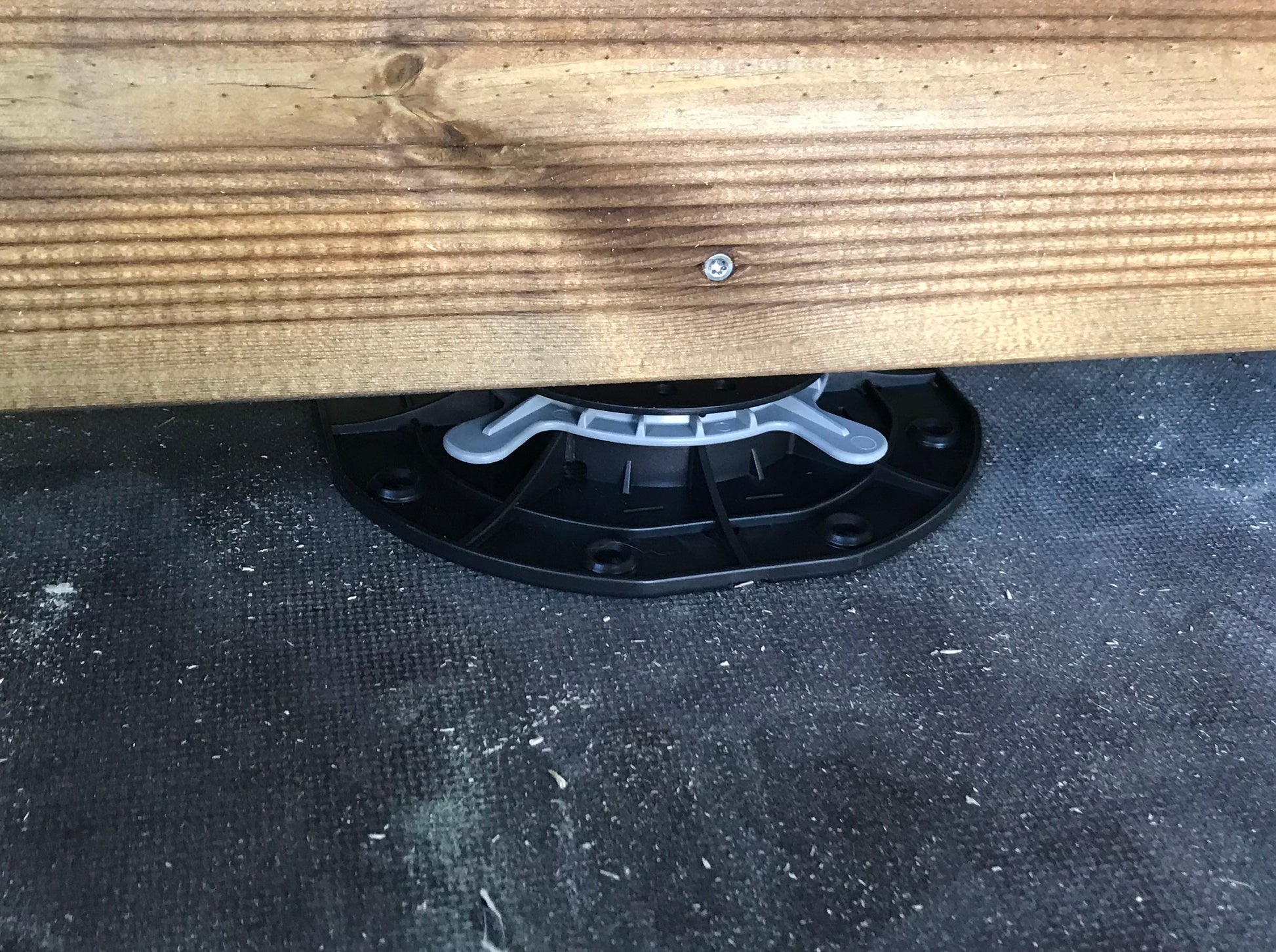 Black plastic legs bracket attached to a wooden surface