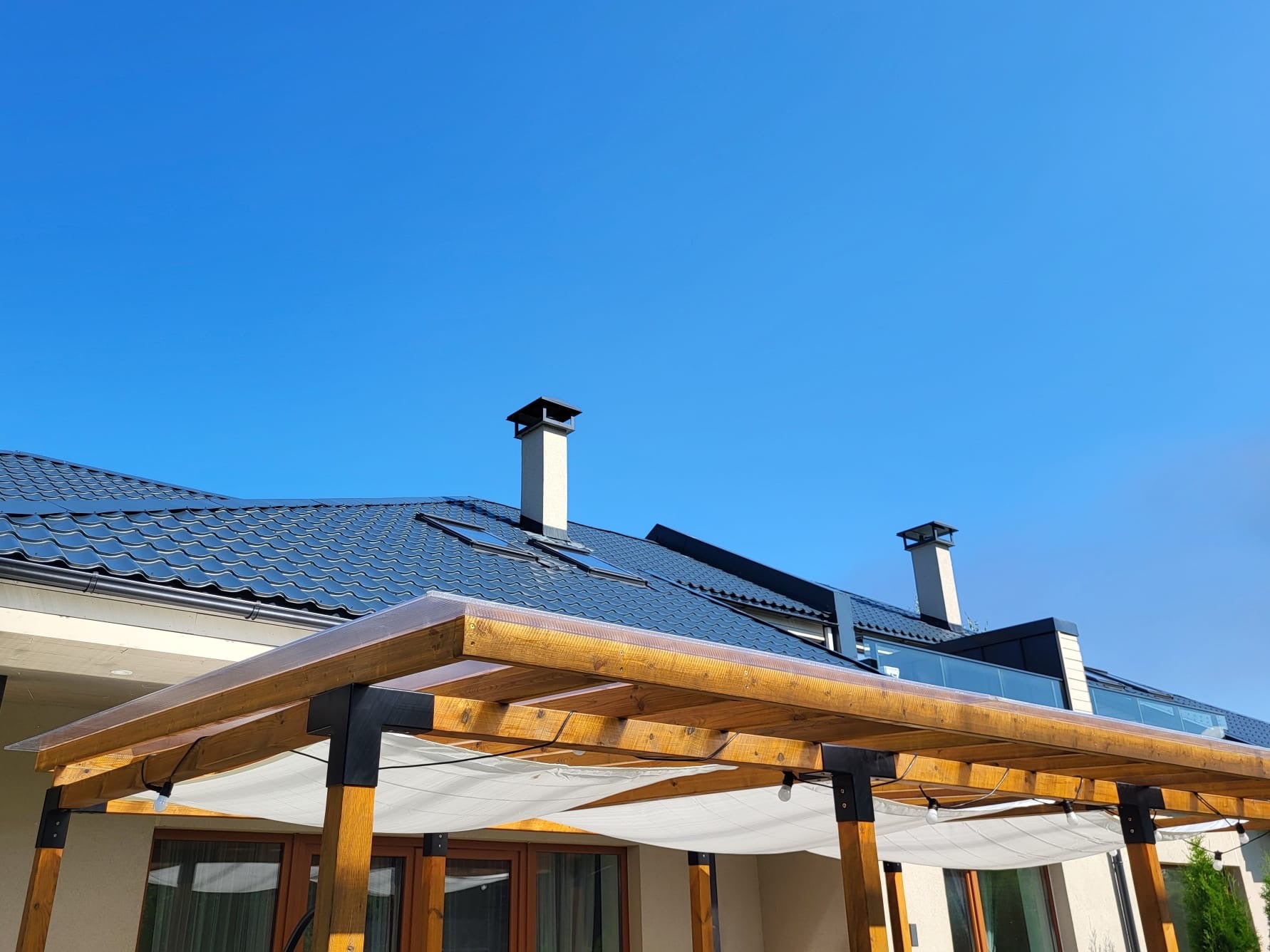 Roof of a house with solar panels and a clear blue sky