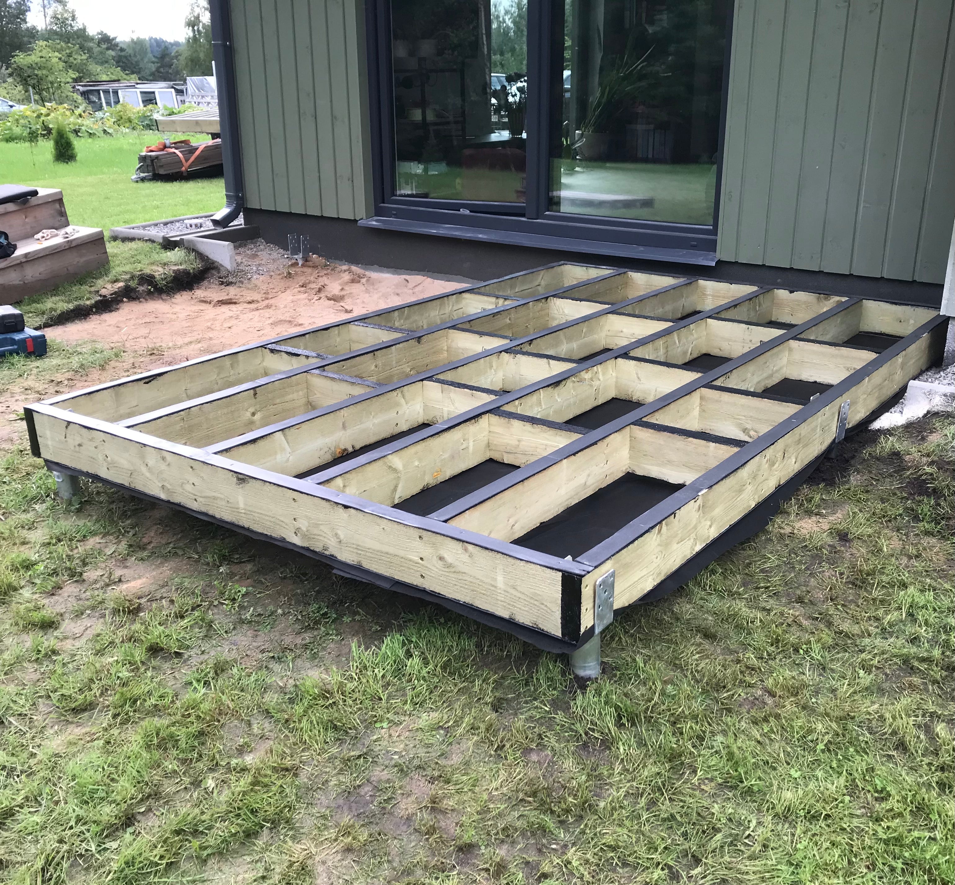 Wooden floor framework being built in front of a house