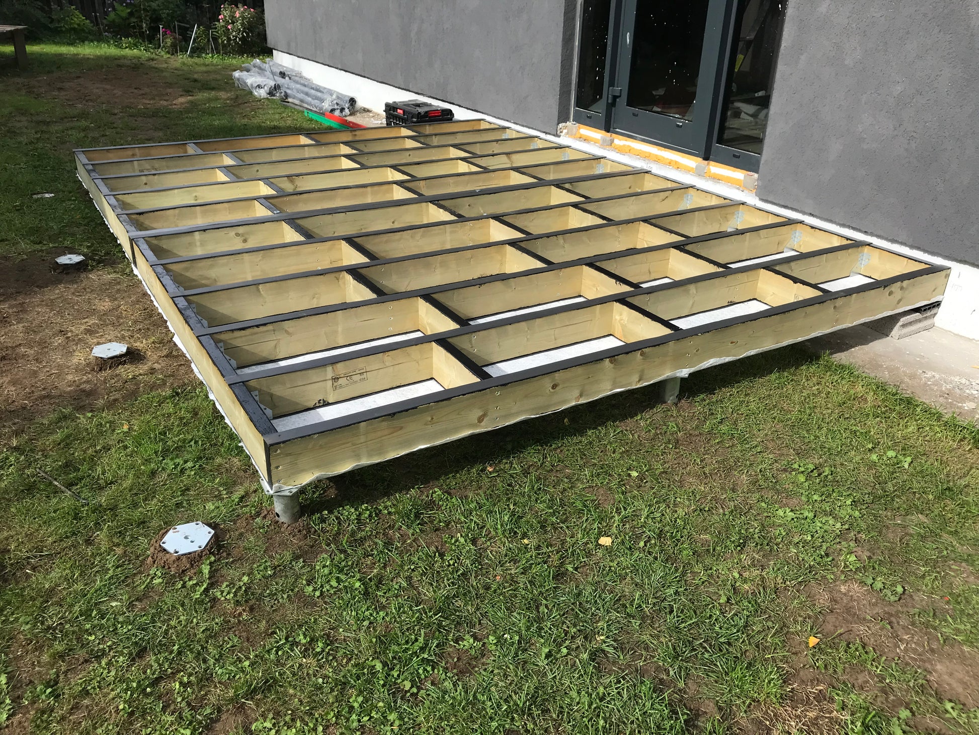 Wooden deck foundation being built outside a house