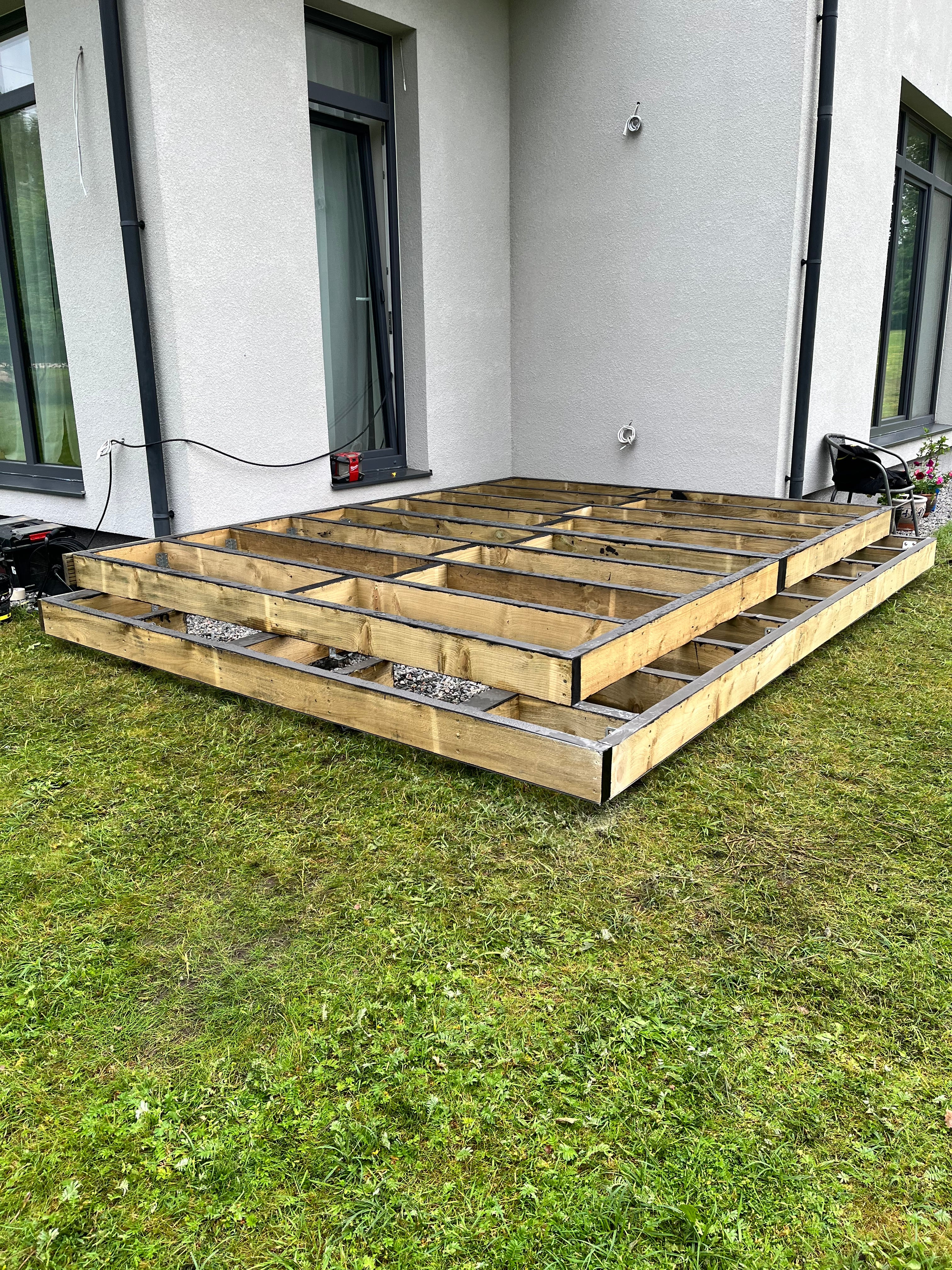 White vehicle with a wooden railing on a grassy area