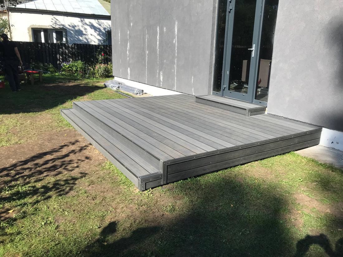 Gray wooden deck leading to a house entrance