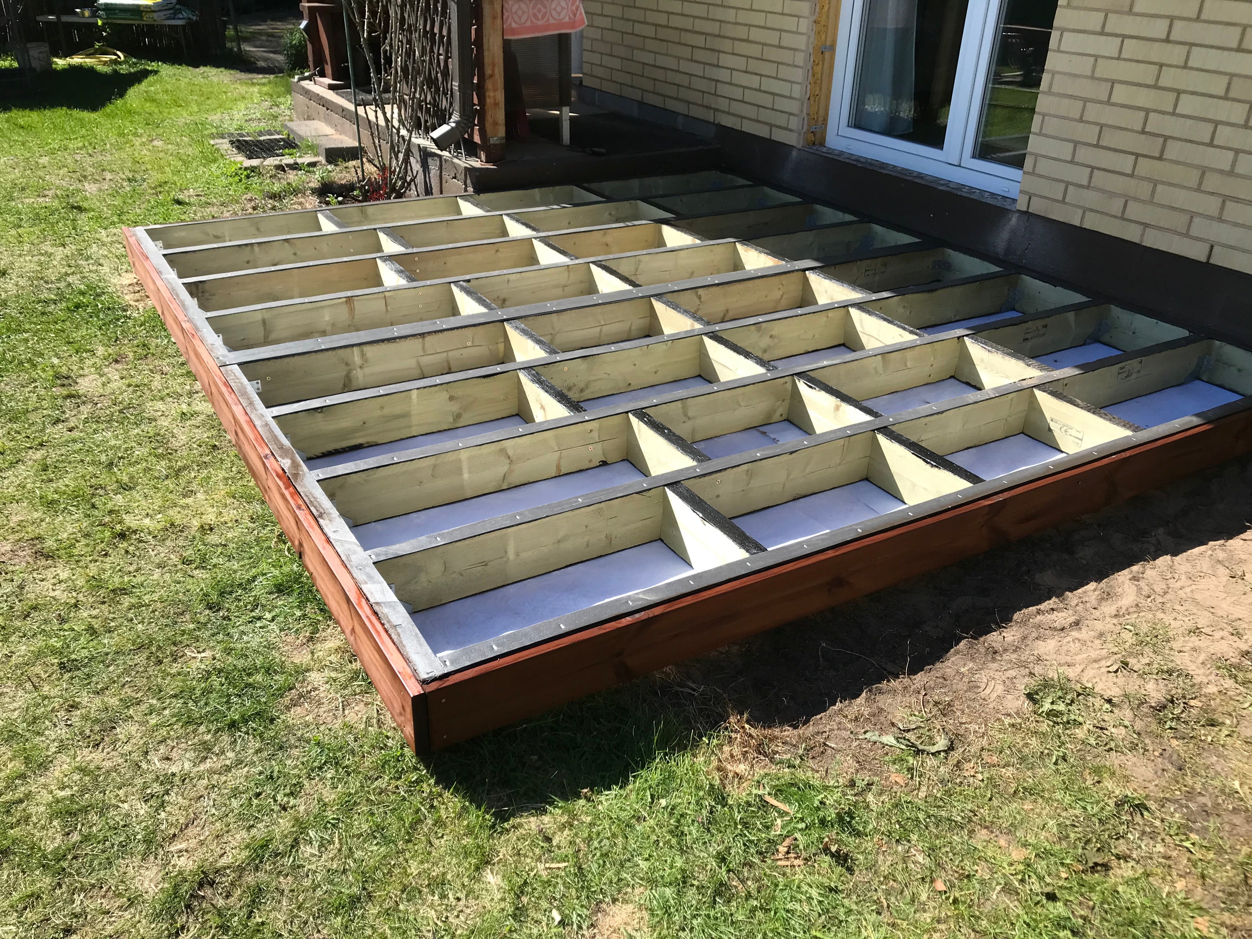 Wooden deck foundation with concrete base in a backyard setting