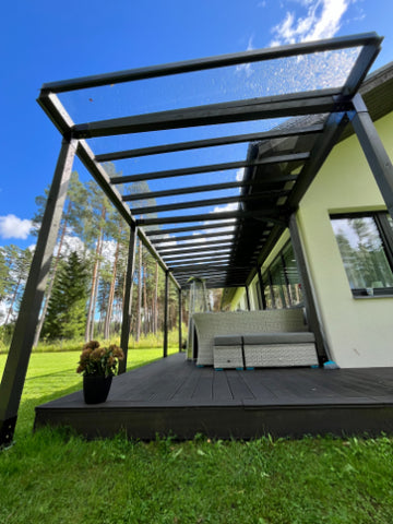 Canopy structure and a deck with a green lawn and trees in the background