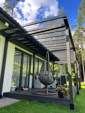 Modern outdoor patio with pergola, swing, and flowers on a sunny day.