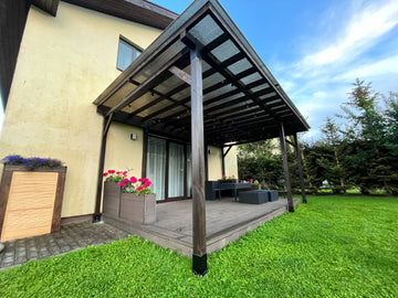 Patio with wooden pergola, outdoor furniture, and plants on a sunny day.