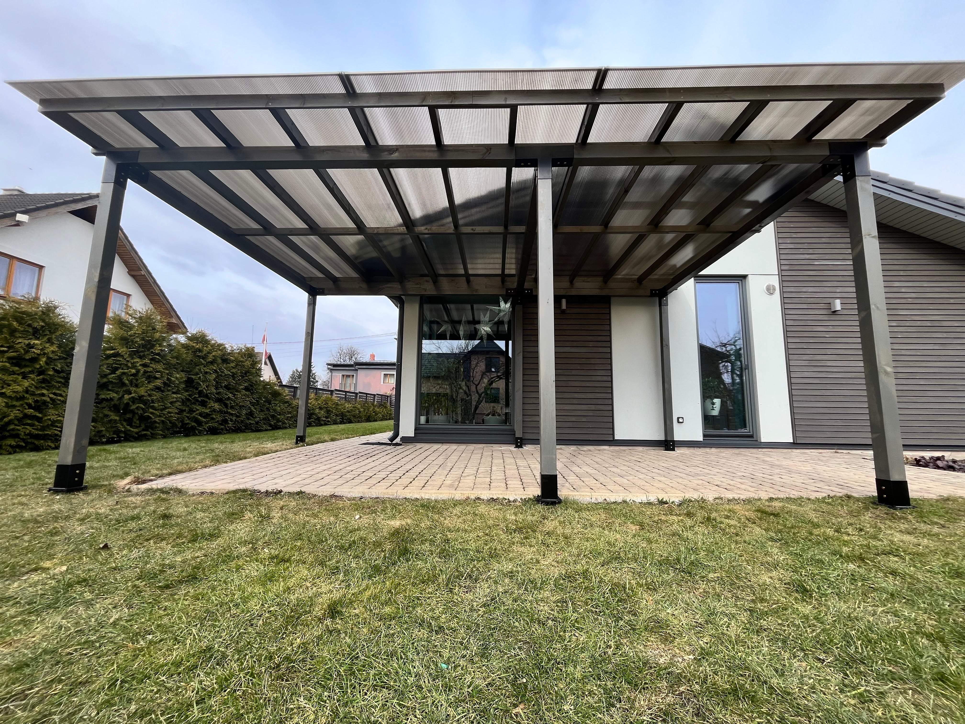 Modern carport attached to a house with a clear sky background