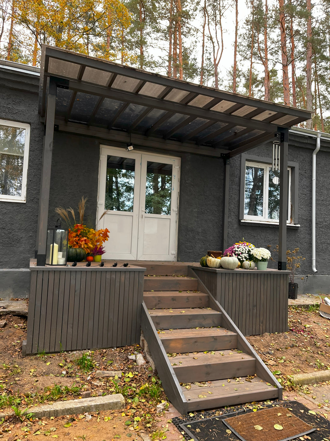 Modern house exterior with a wooden pergola and decorative elements.