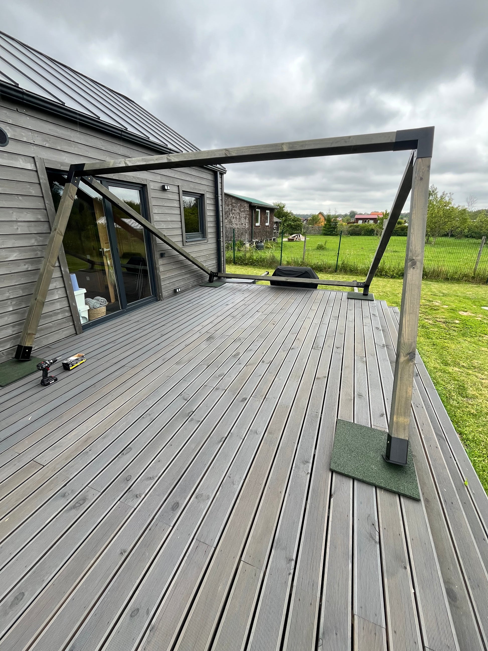 Wooden deck with glass balustrade overlooking a green landscape