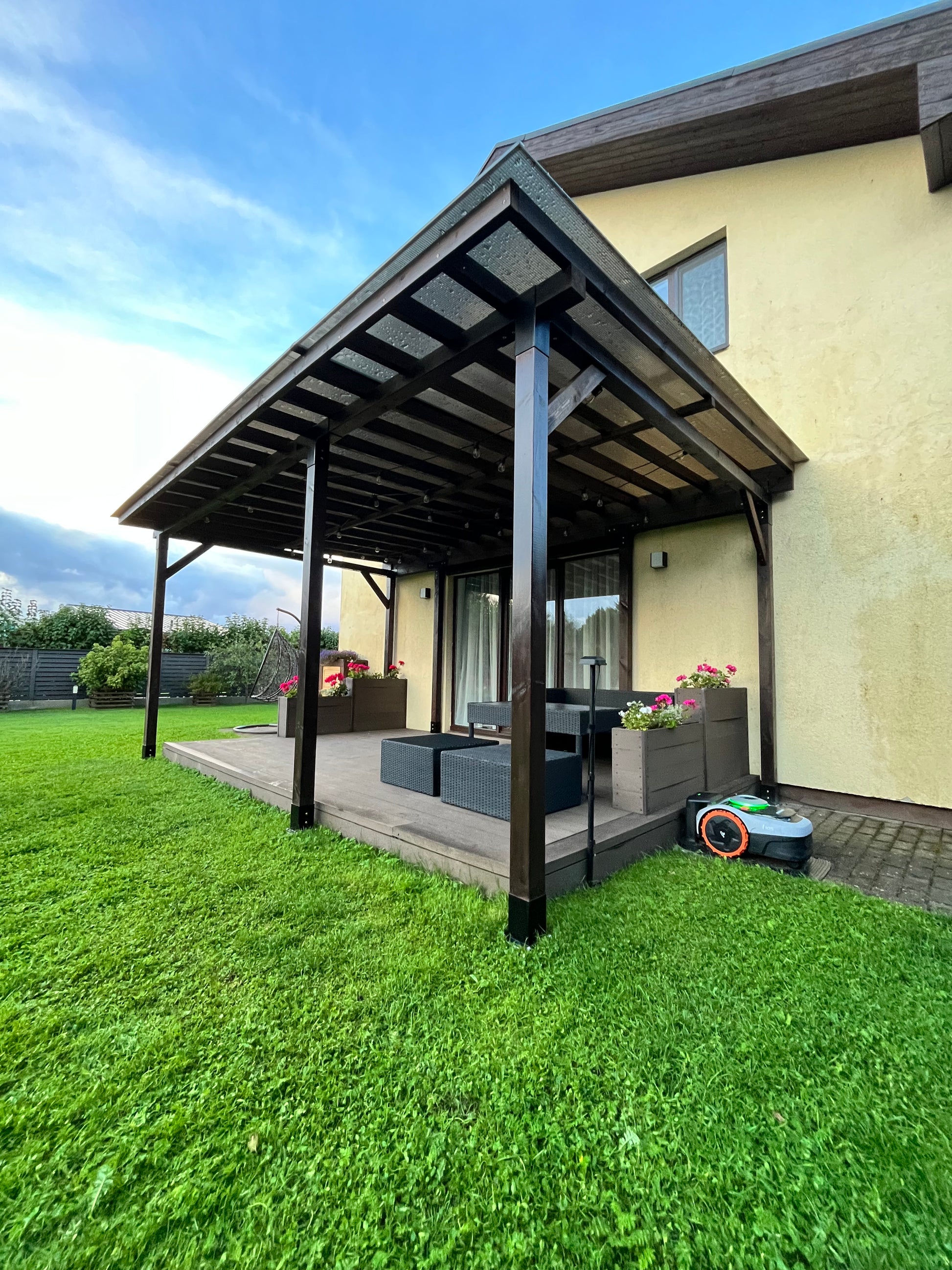 Outdoor patio area with a table and chairs on a grassy lawn.