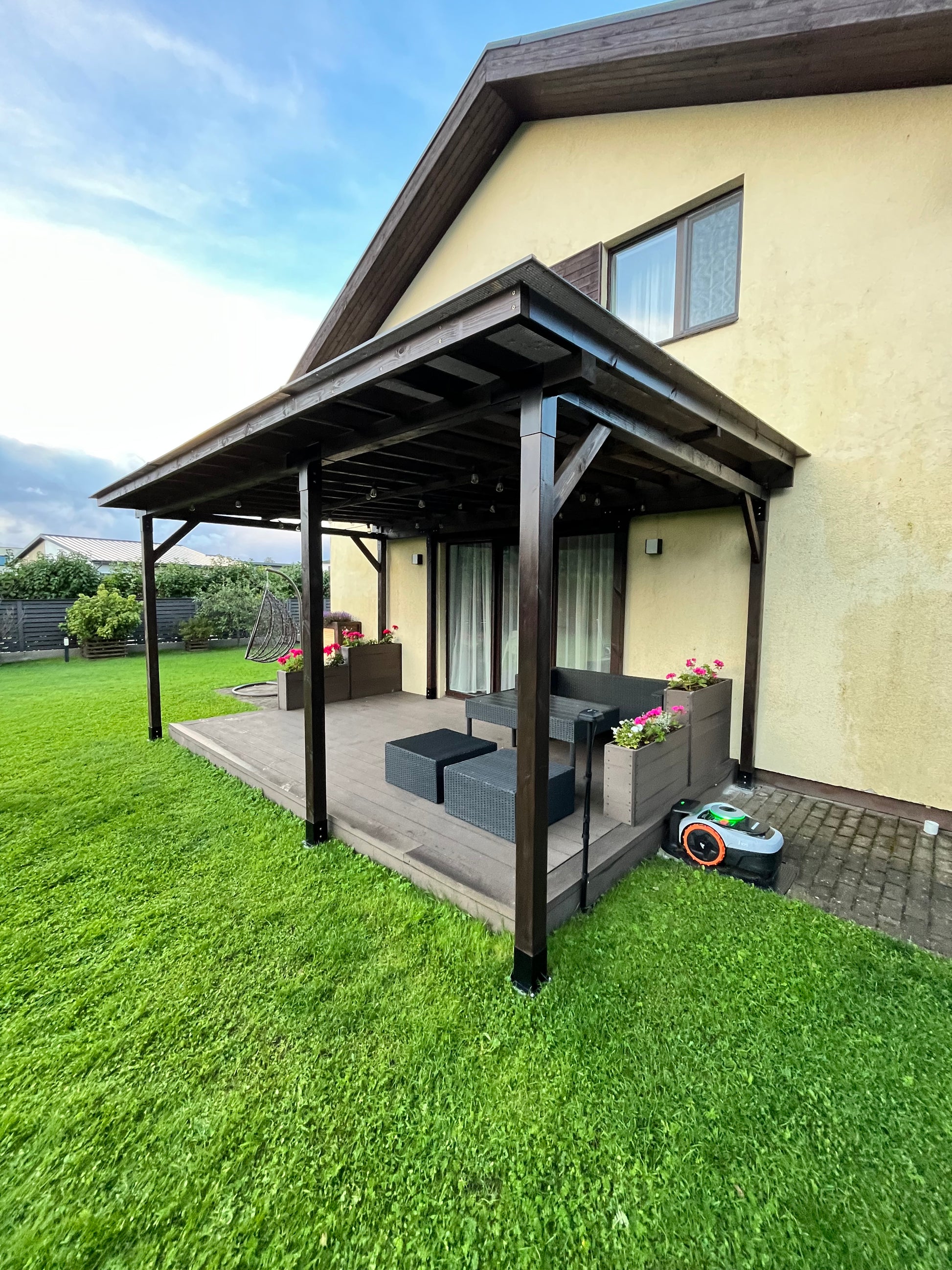 Balcony with canopy and outdoor furniture on a grassy area