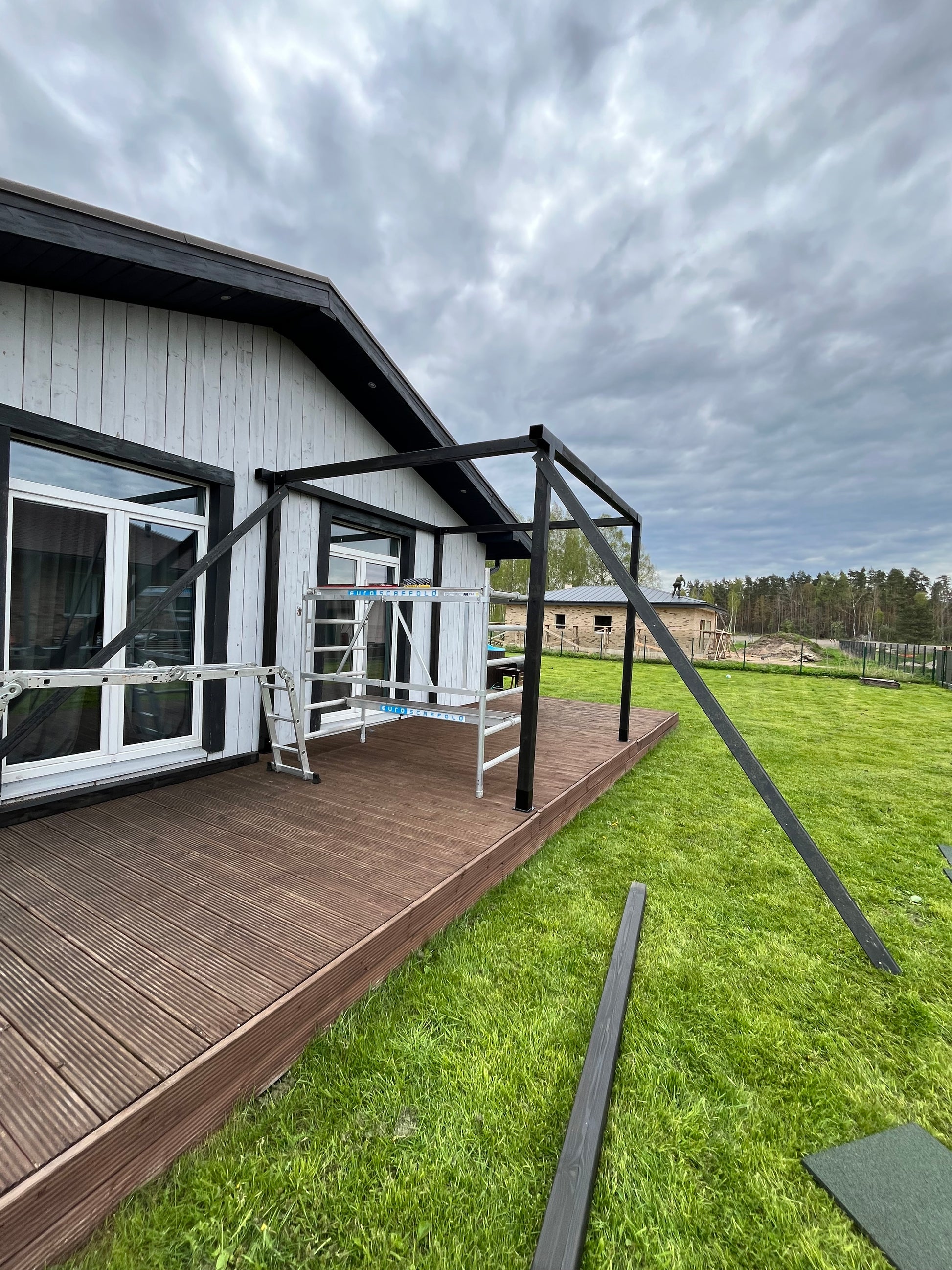 Fire escape ladder on a building exterior with grass and sky in the background
