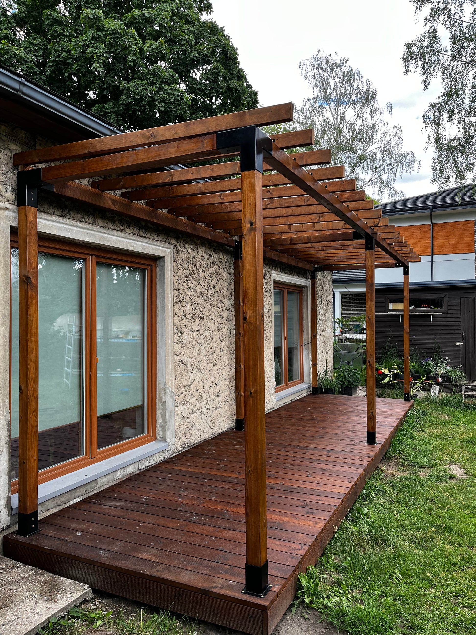 Wooden deck with glass panels leading to a house entrance