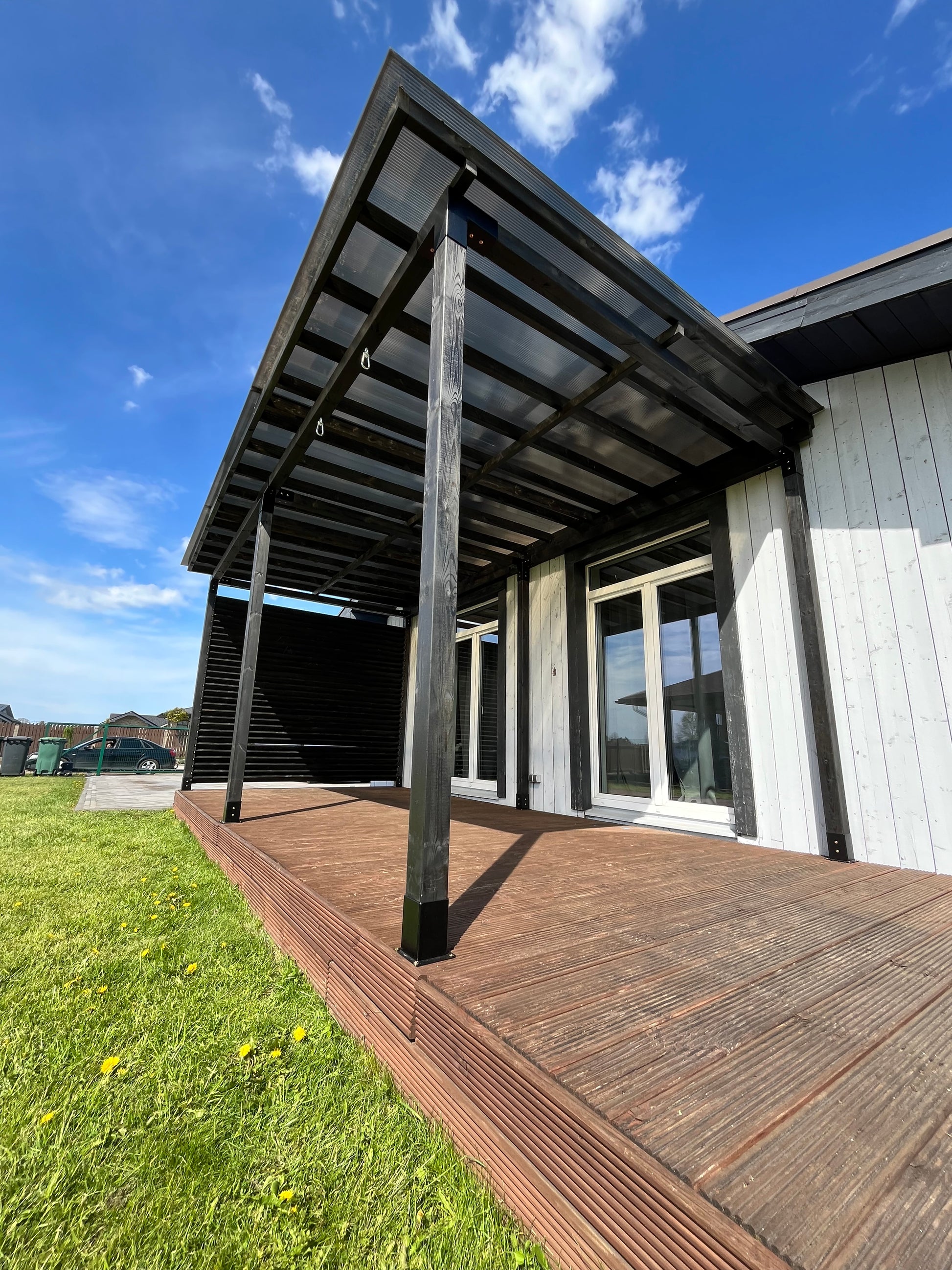 Outdoor deck with a railing overlooking a clear blue sky