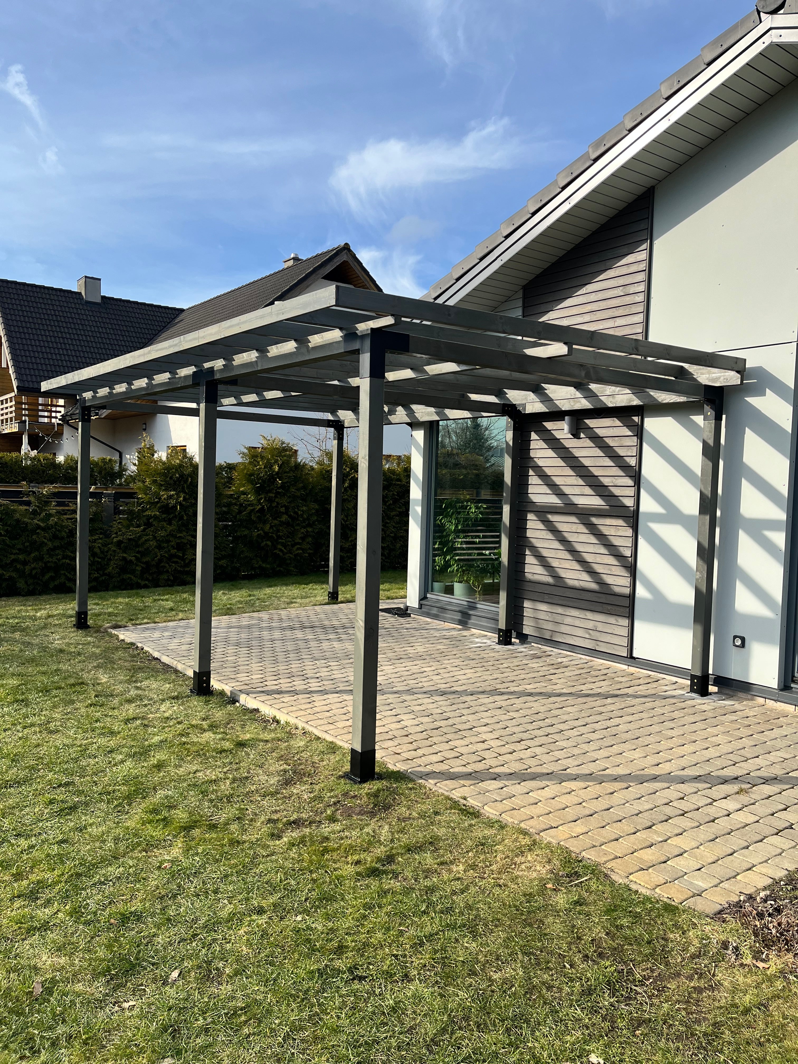 Pavilion with glass walls on a sunny day, featuring a clear blue sky.
