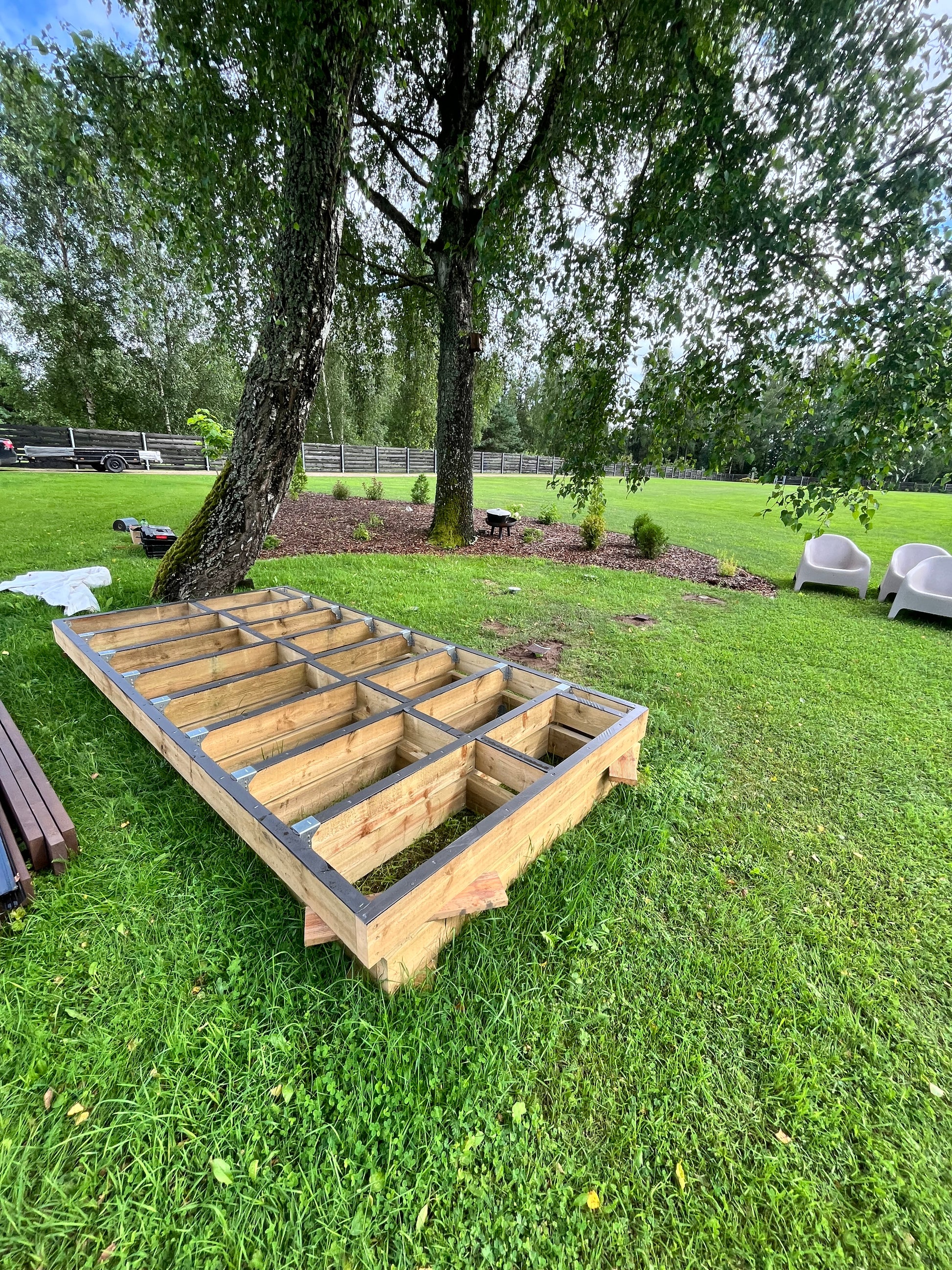 Wooden structure on a grassy area with trees in the background