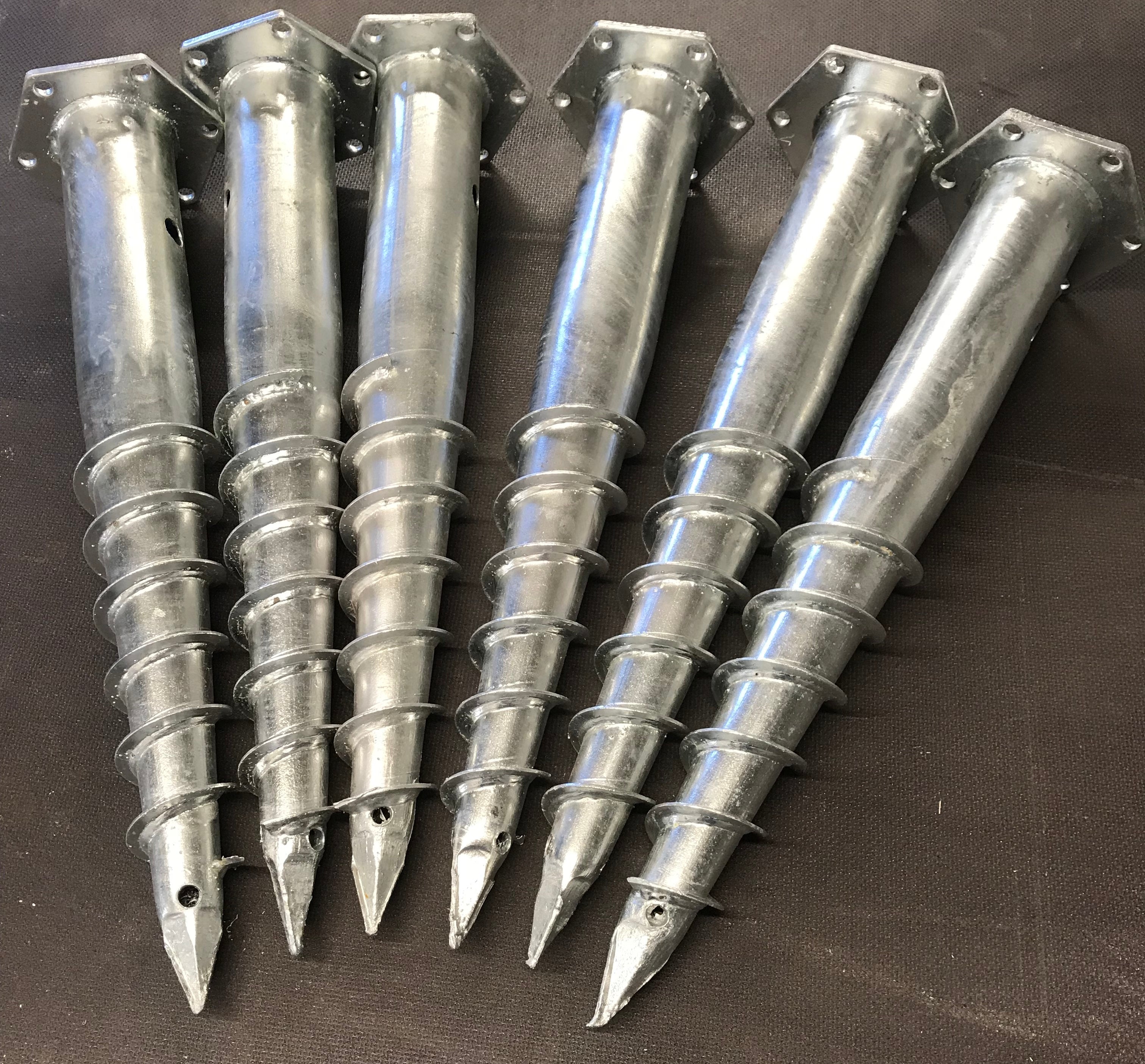 Metal stakes with pointed tips on a dark background