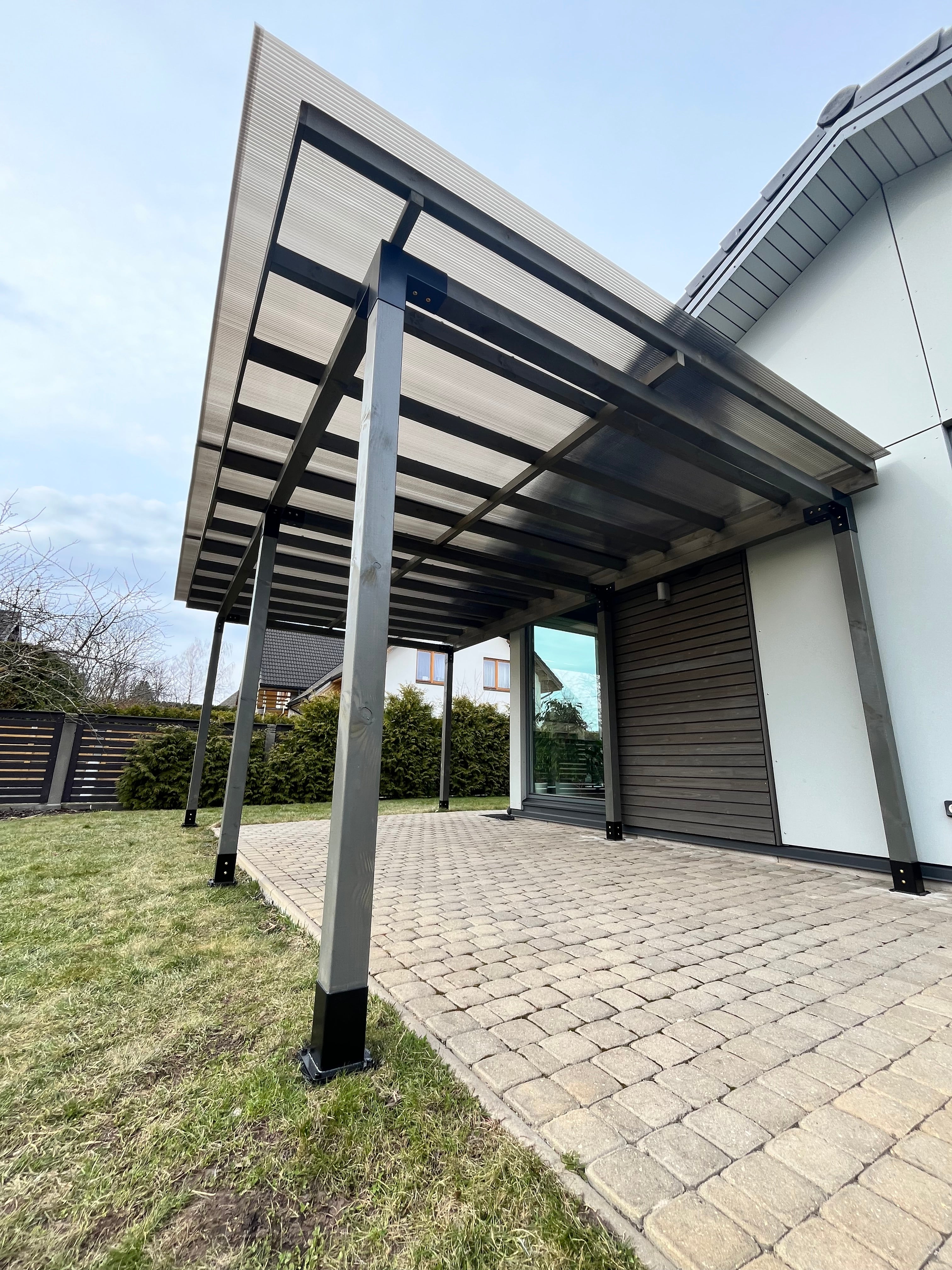 Modern house exterior with a metal staircase leading to a glass door.