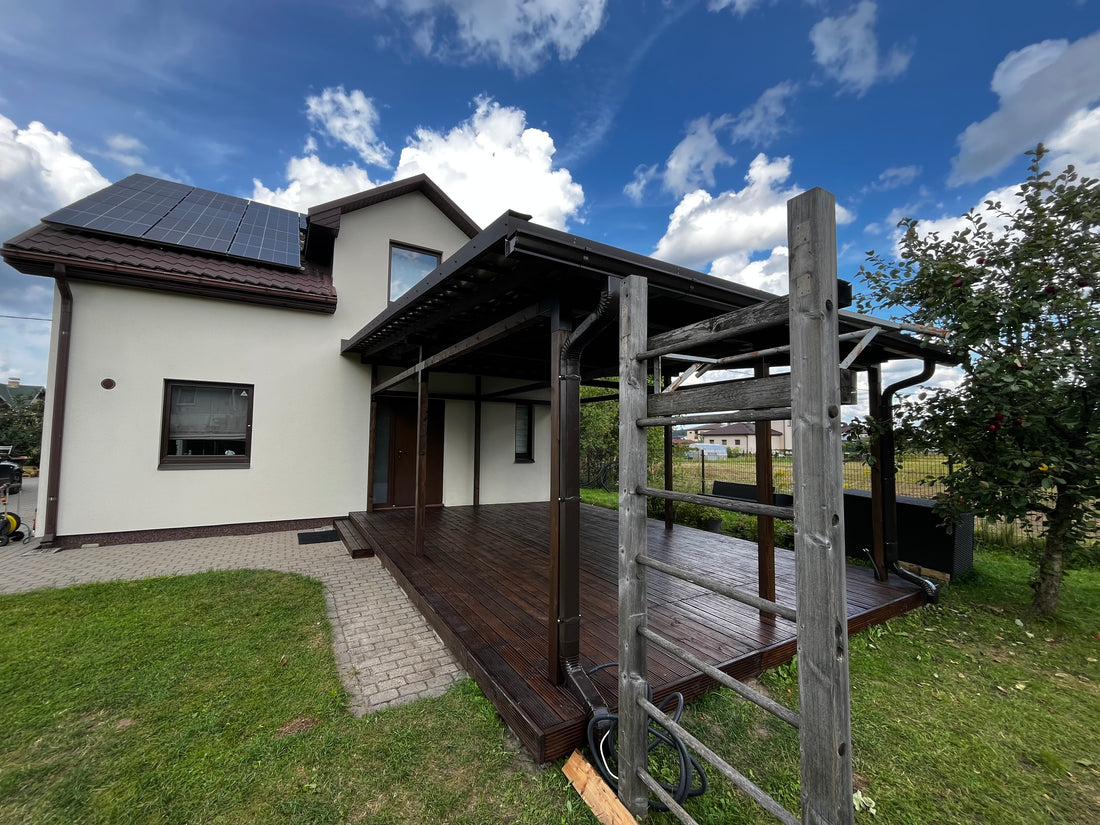 Modern house with a wooden deck and solar panels on a clear day