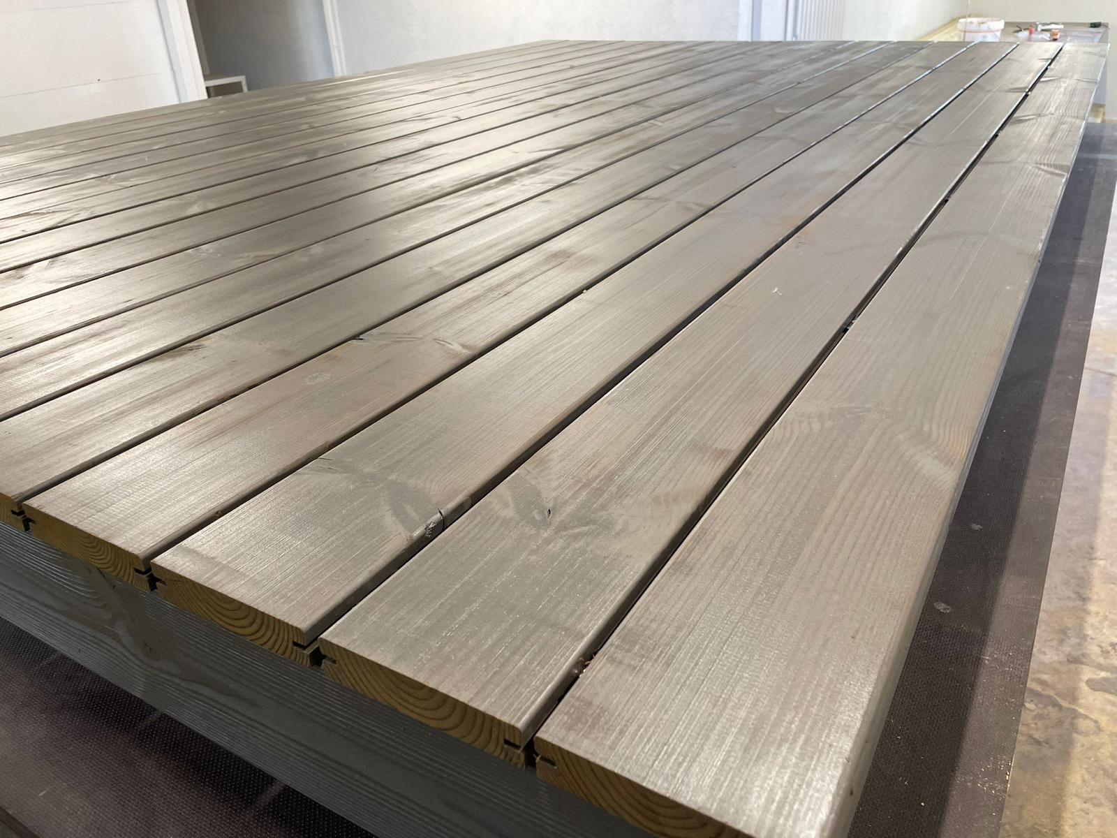 Wooden termo deck boards stacked on a flat surface