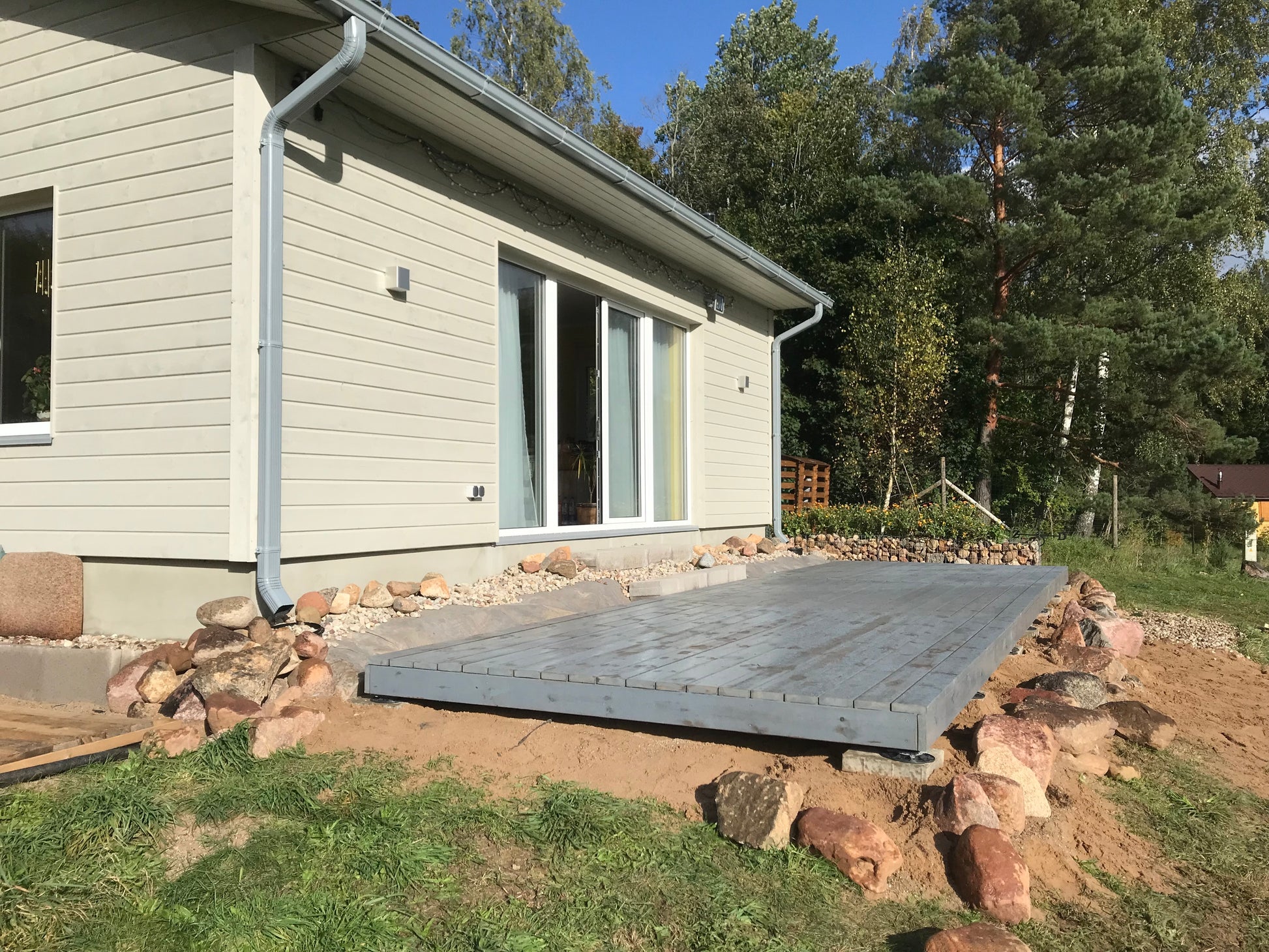 House exterior with a newly constructed wooden deck in a natural setting.