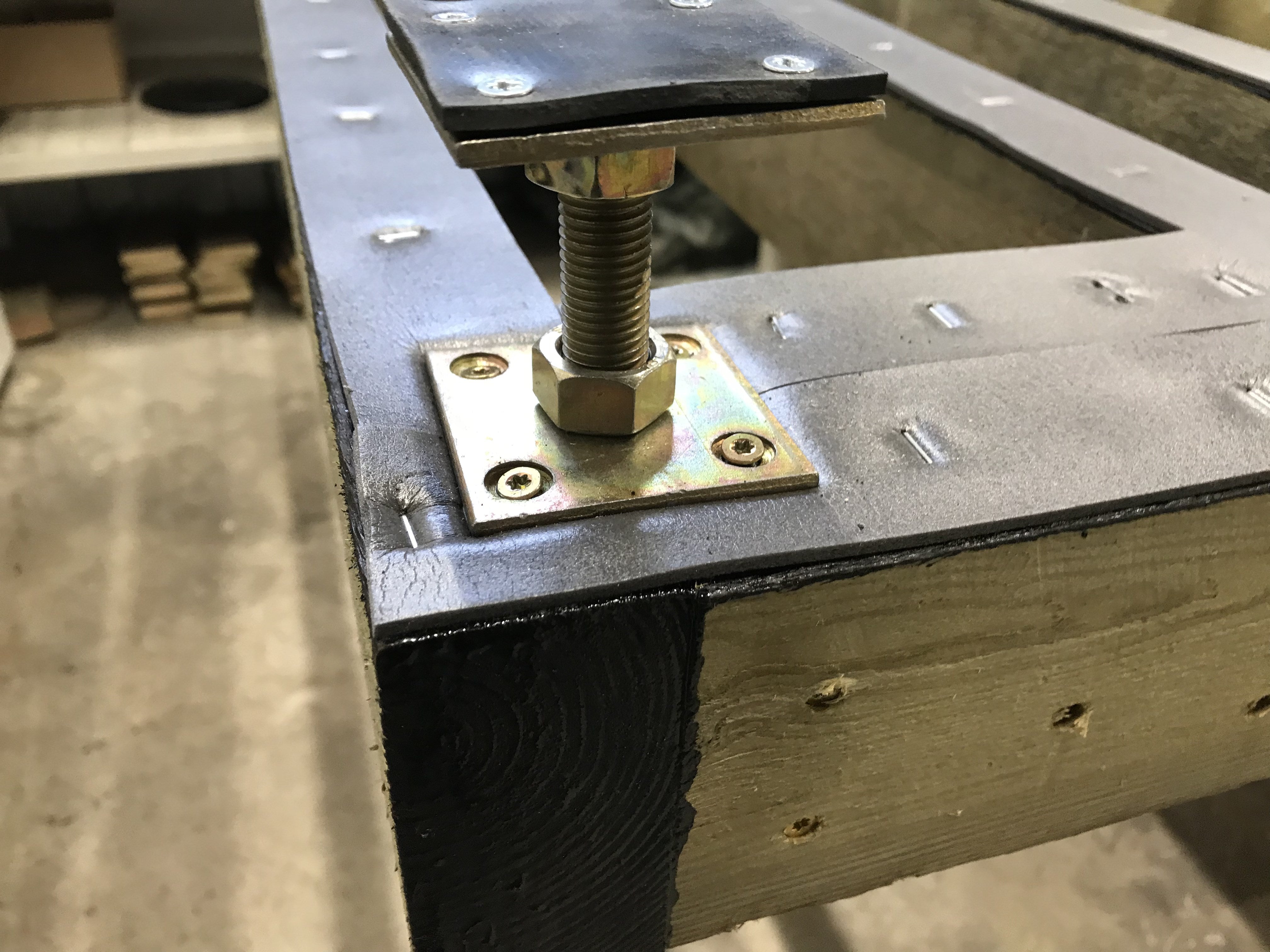 Metal bracket with bolts on a wooden surface