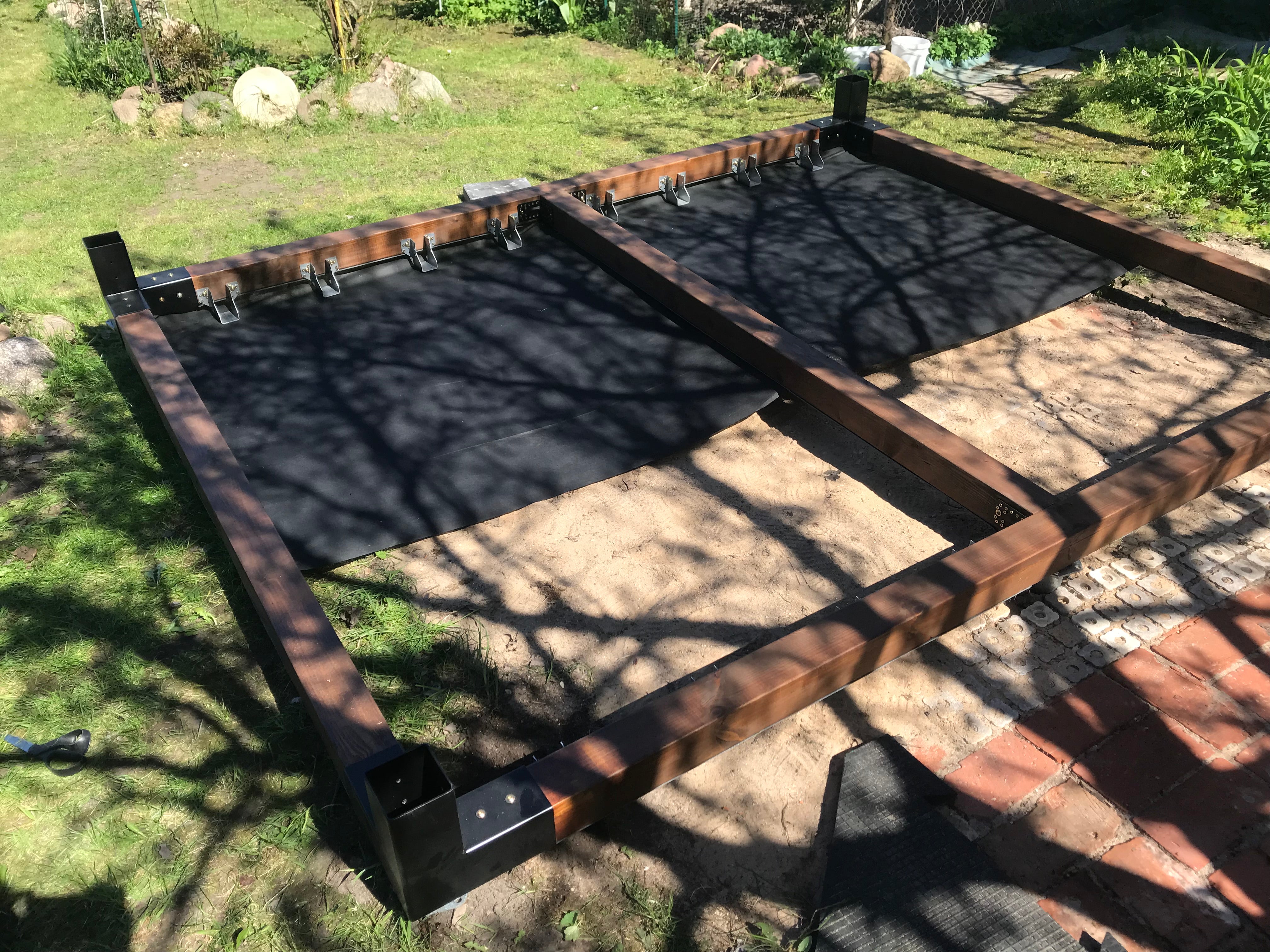 Metal frame on a grassy area with shadows cast by trees