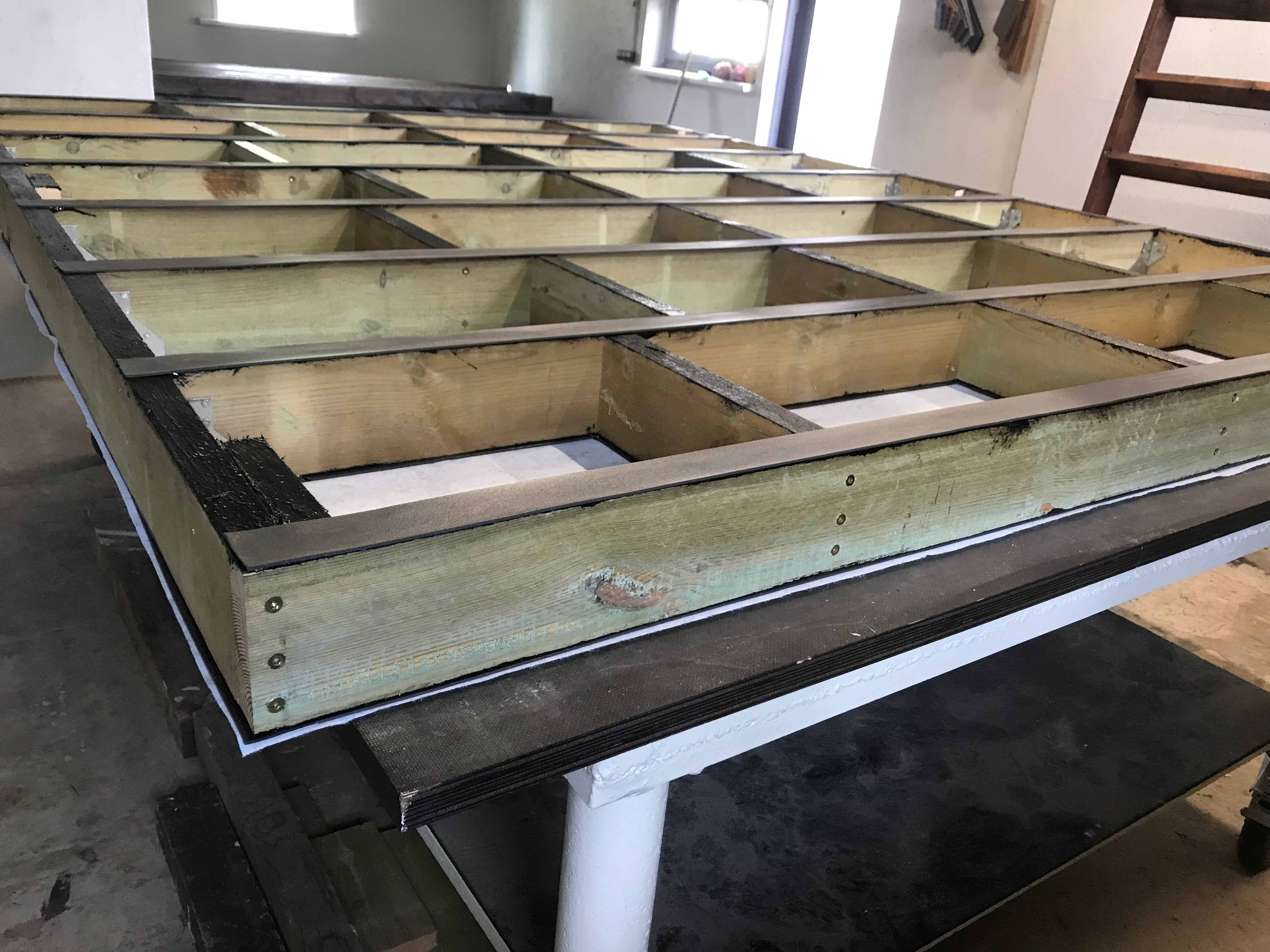 Wooden frame structure on a workbench in an indoor setting