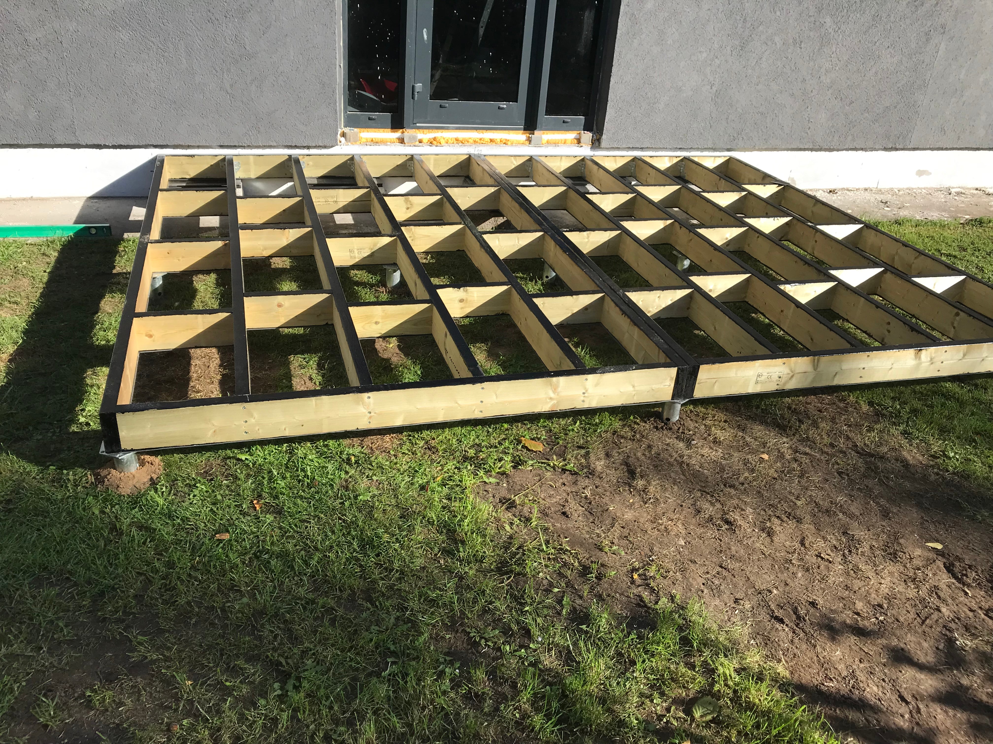 Wooden pallet on grass with a building in the background