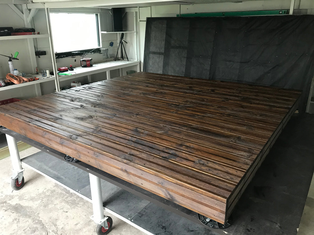 Wooden platform in a backyard with a cabin in the background