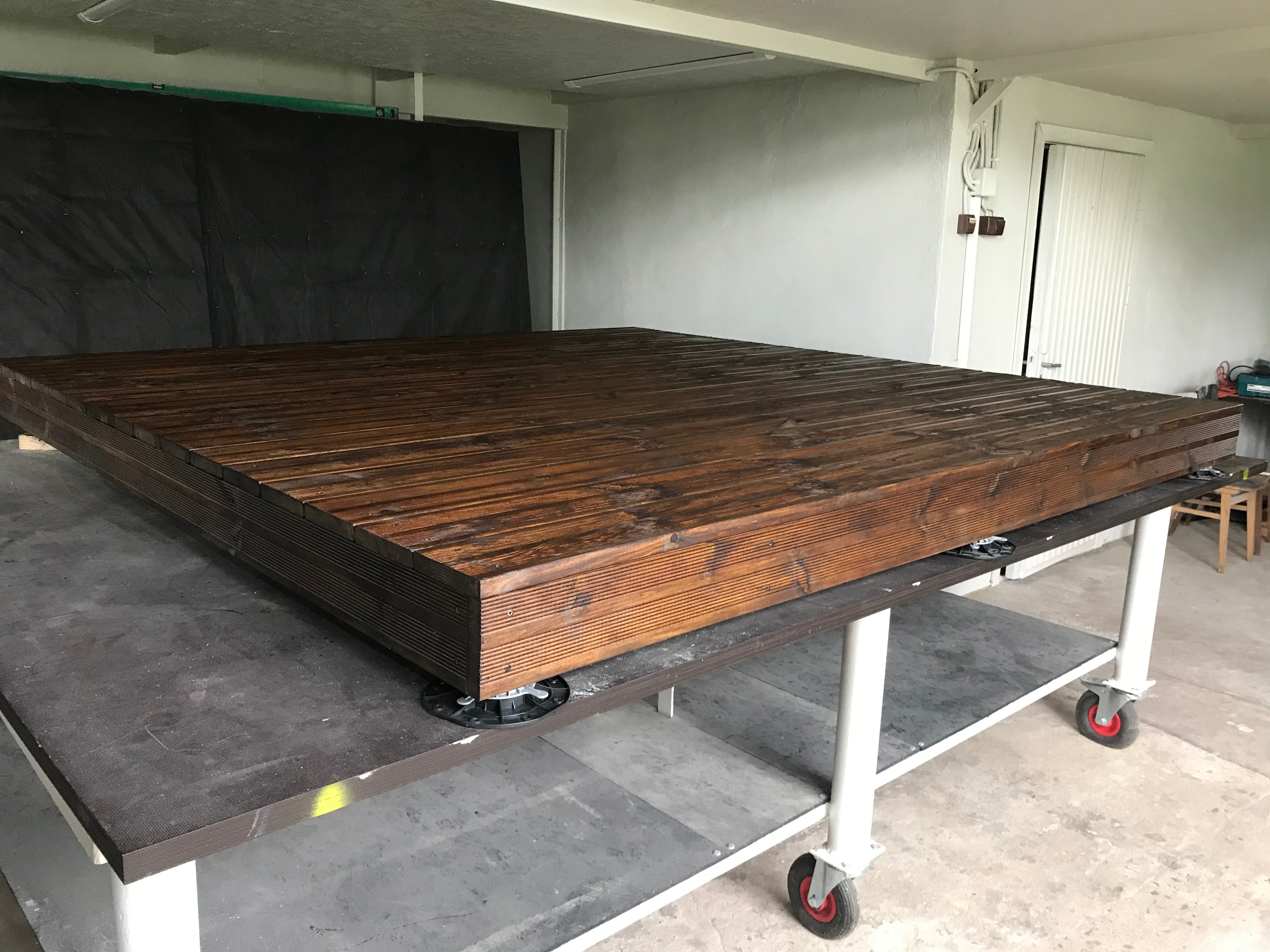 Wooden platform on wheels in a garage setting