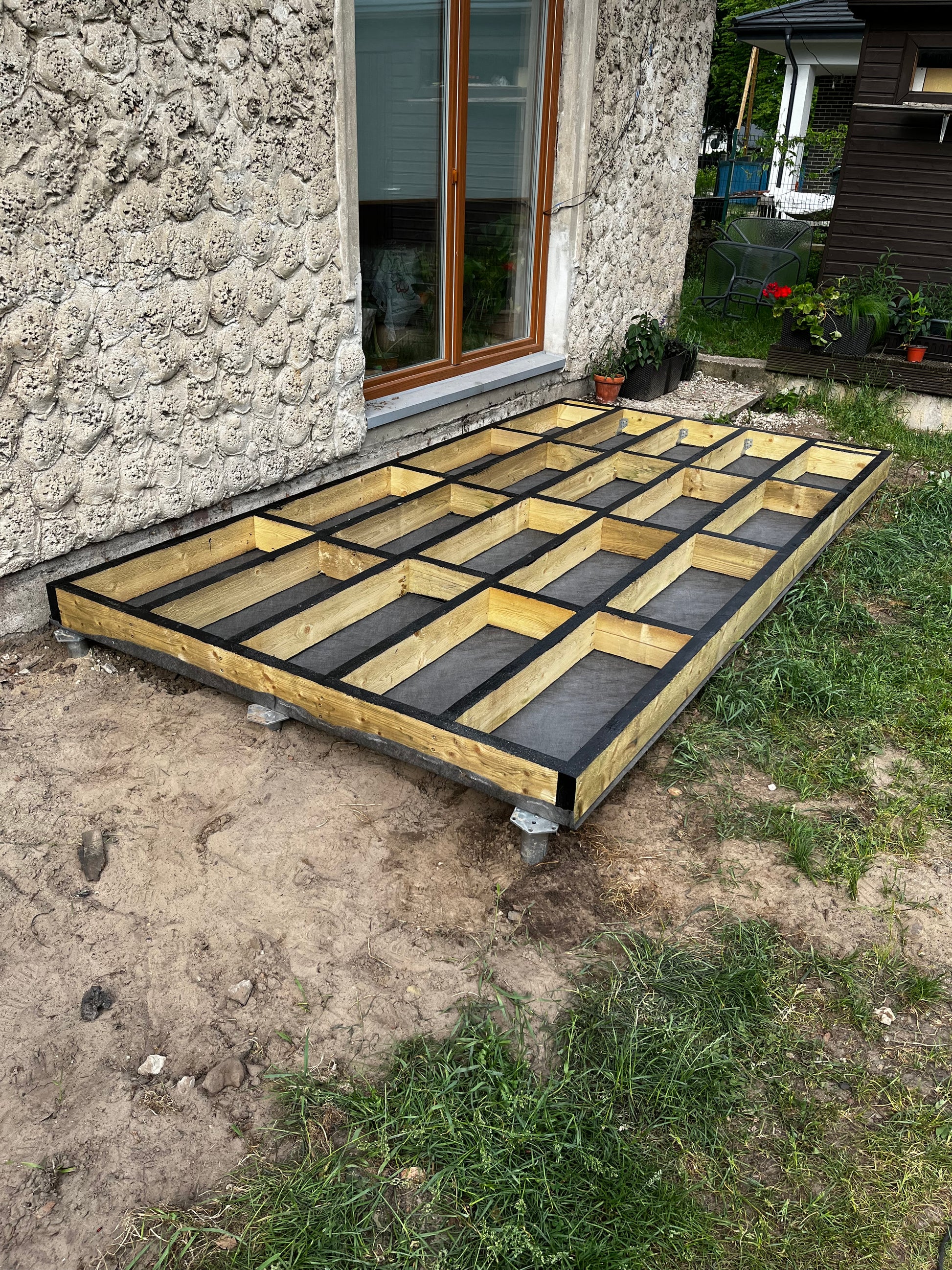 Building deck foundation with insulation material next to a house