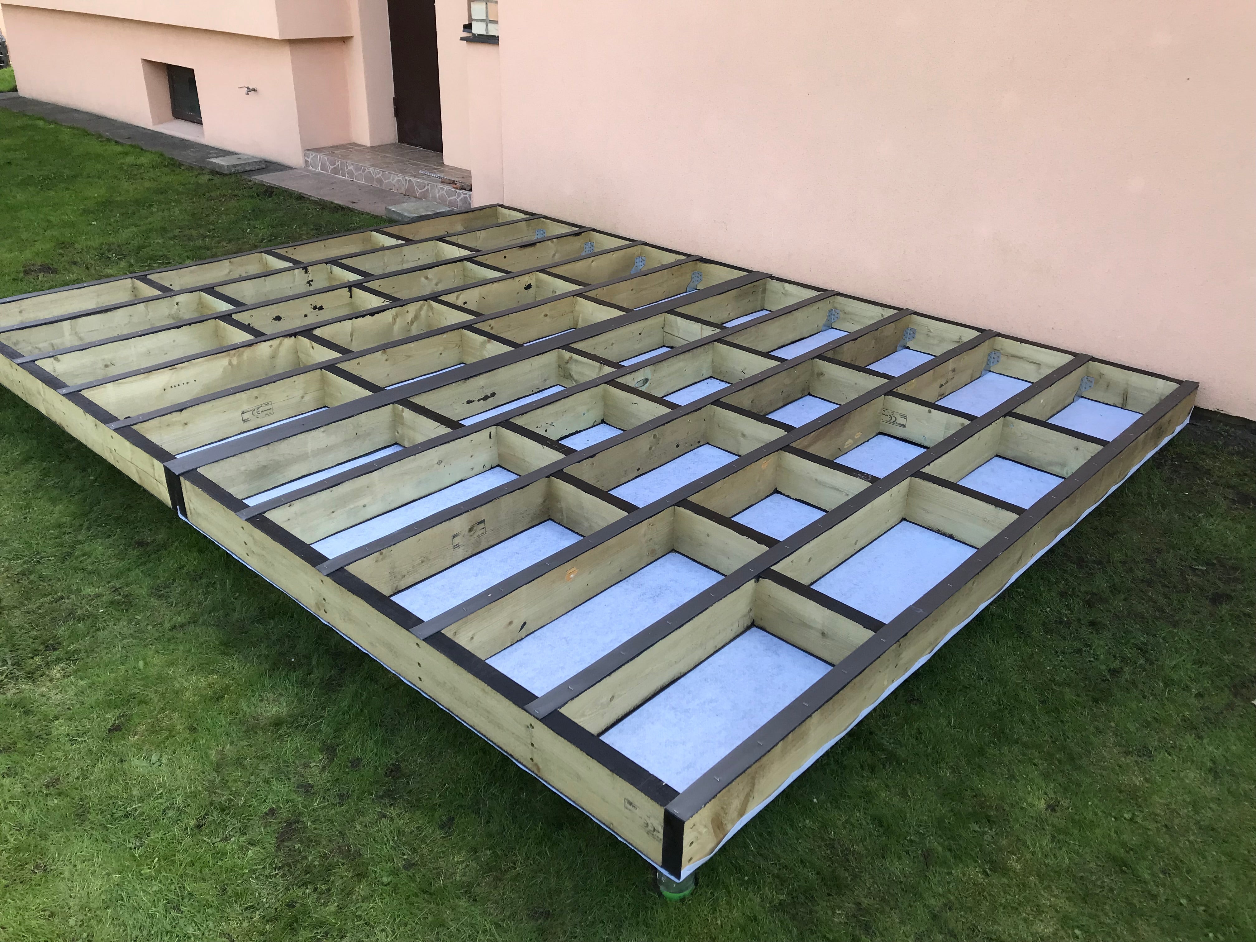 Wooden floor frame with concrete slabs on a grassy area