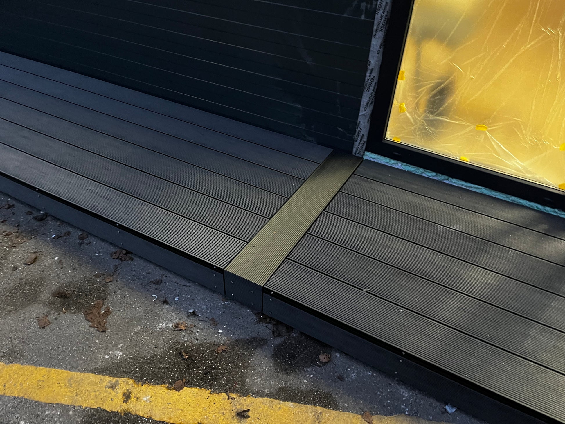 Wooden deck with a step leading up to a glass door