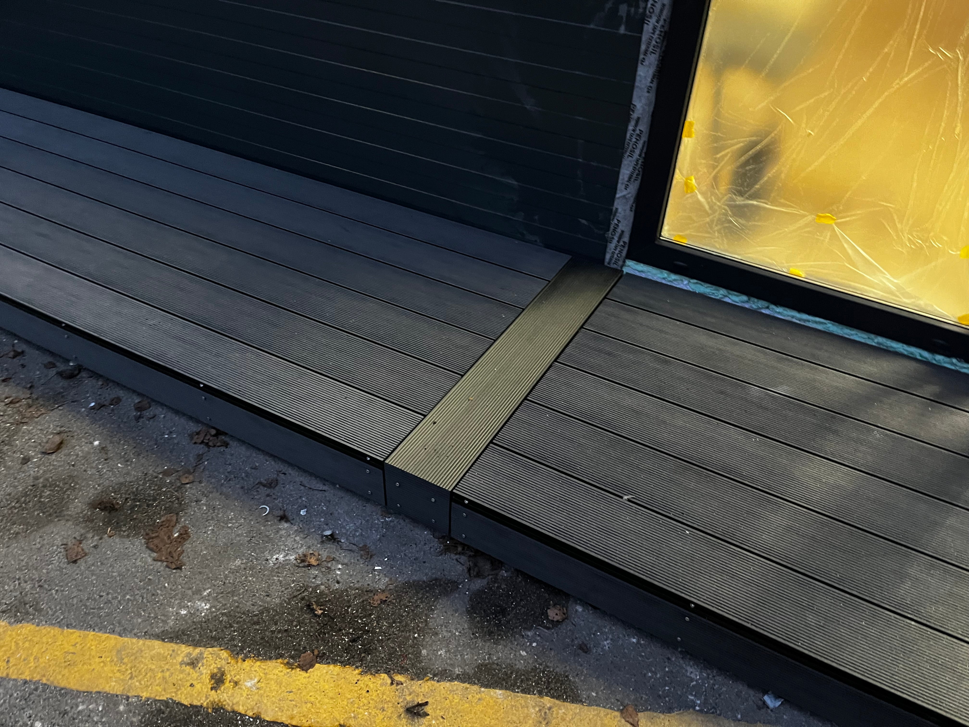 Wooden deck with a step leading up to a glass door